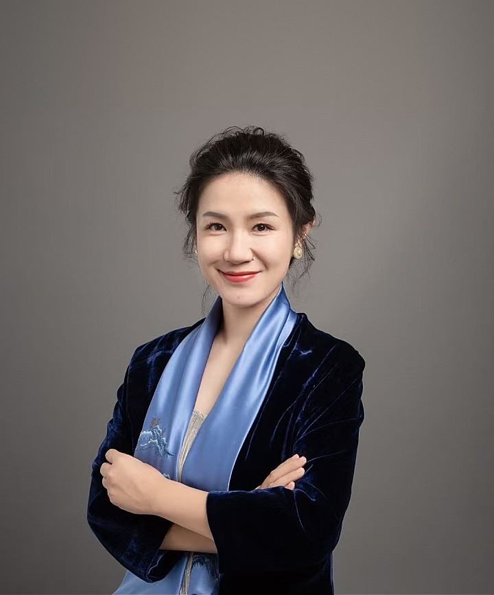 林海丹肖像:身穿深蓝丝绒外套、系浅蓝丝巾,双臂交叉,面带微笑