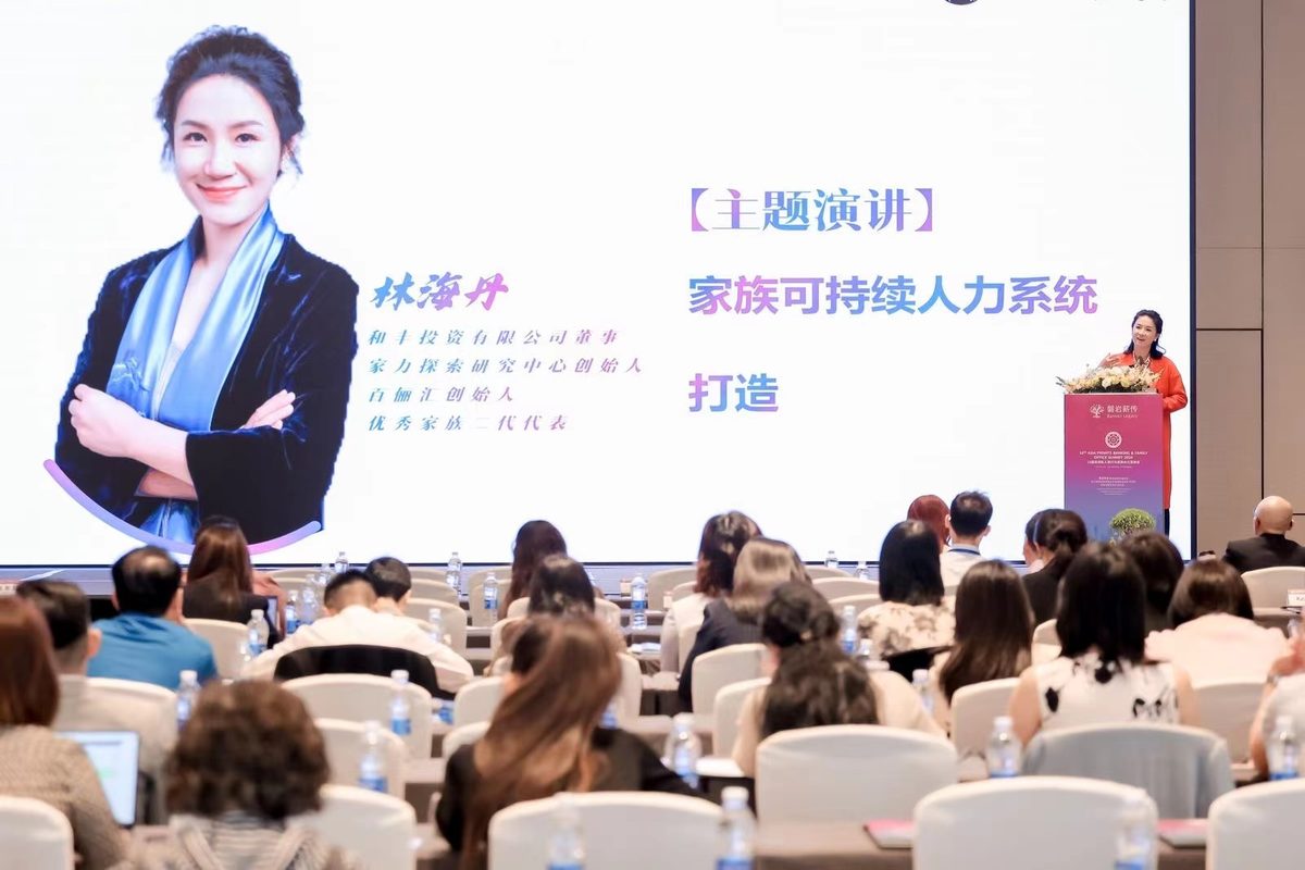 林海丹在第16届亚洲私人银行与家族办公室峰会上作主题演讲《家族可持续人力系统打造》，大屏上是她的名字和演讲题目